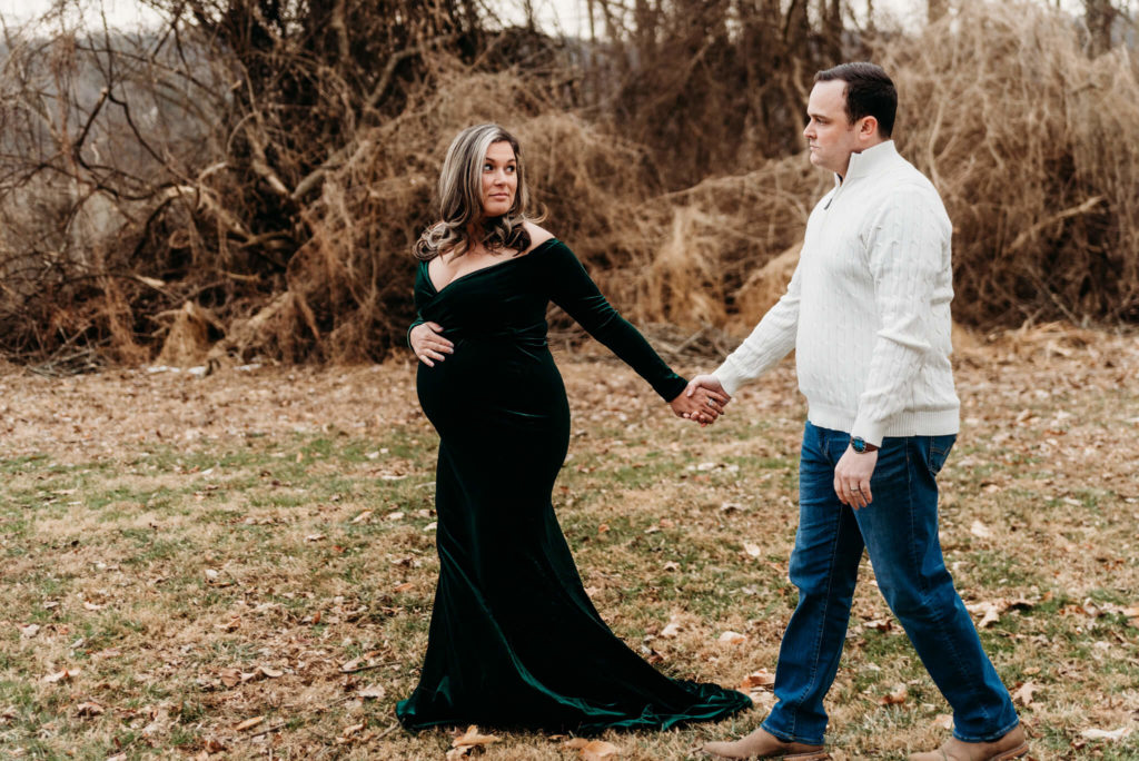 Couple holding hands in maternity photos