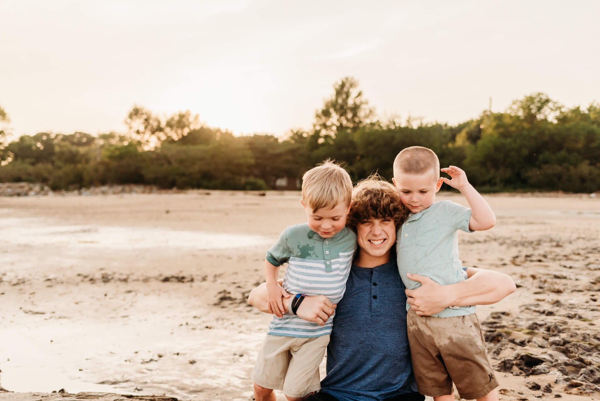 Three siblings hugging on a beach featured in a post about Wilmington Montessori Schools